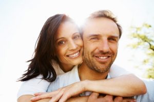 Cheerful woman hugging man from behind